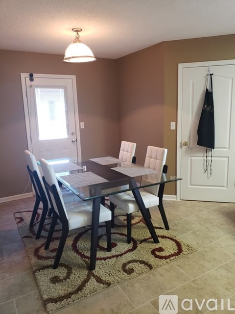 A dining room with a glass table and chairs.