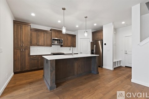 A kitchen with wooden cabinets and a white island.
