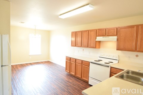 A kitchen with wooden cabinets and a white fridge.