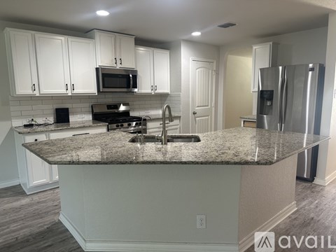 A kitchen with granite countertops and white cabinets.