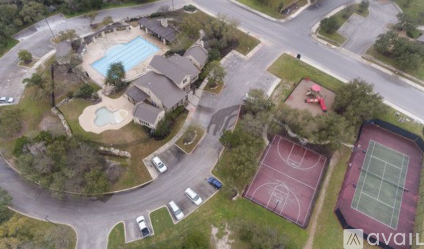 A bird's eye view of a residential area with a swimming pool, tennis court, and basketball court.