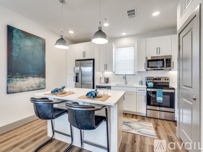 A modern kitchen with a large island and stainless steel appliances.