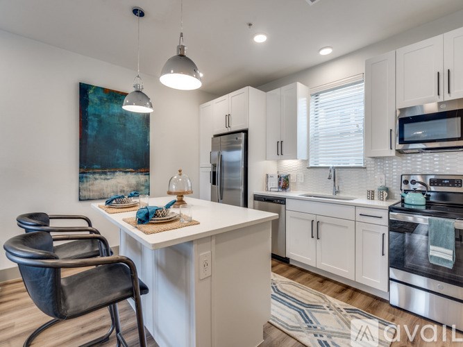 A kitchen with white cabinets and a black chair.