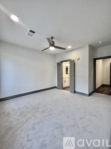 A room with a ceiling fan and carpeted floor.