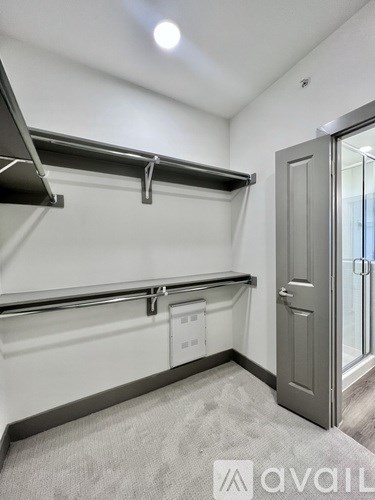 A room with a grey carpet and a grey door.