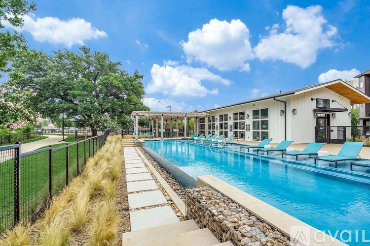 A pool surrounded by a fence with trees in the background.