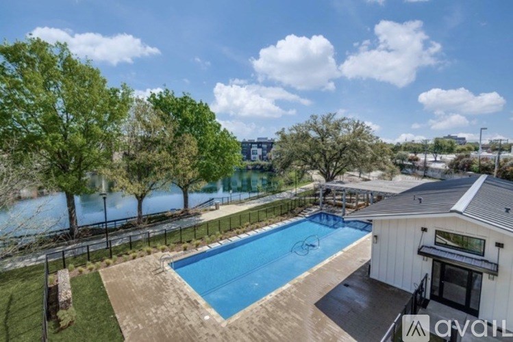 A pool surrounded by a fence with trees in the background.