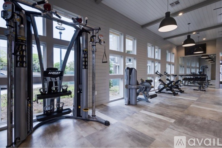 A gym with a variety of equipment including a squat rack and a treadmill.