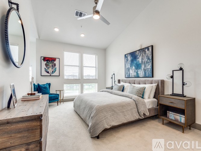 A bedroom with a large bed, a dresser, and a mirror.