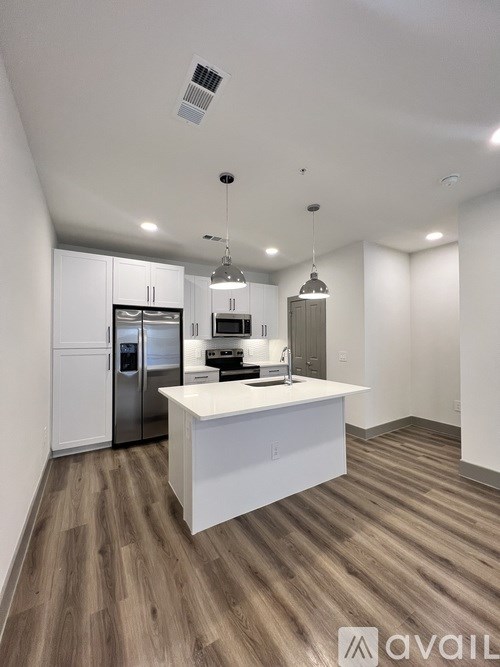 A kitchen with a white island and stainless steel appliances.