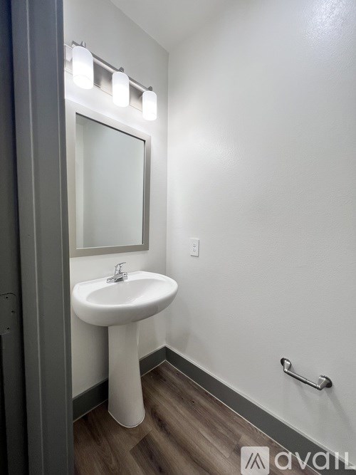 A white pedestal sink in a small bathroom.
