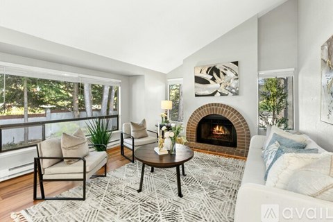 A living room with white furniture and a fireplace.