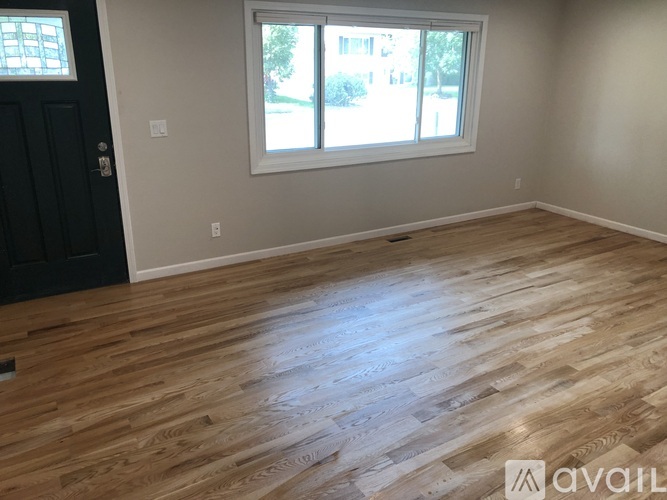A room with wooden flooring and a window.