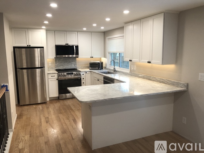 A modern kitchen with a refrigerator, stove, and oven.