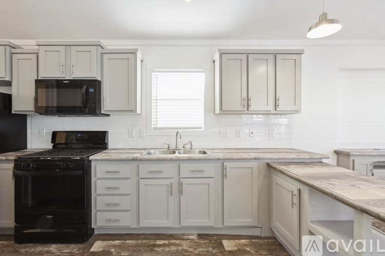 A kitchen with white cabinets and a black oven.