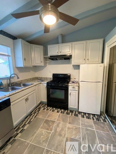 A kitchen with a black stove top oven and white appliances.