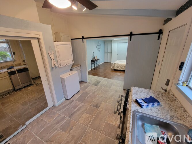 A kitchen with a sink, a refrigerator, and a counter.