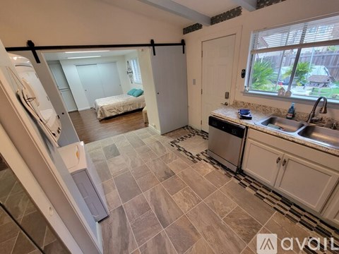 A kitchen with a sink, stove, and refrigerator.
