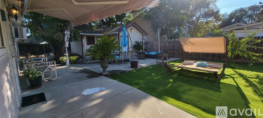 A backyard with a patio and a lawn.