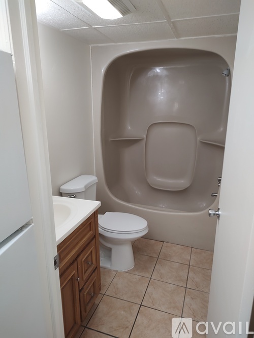 A bathroom with a toilet, sink, and shower stall.