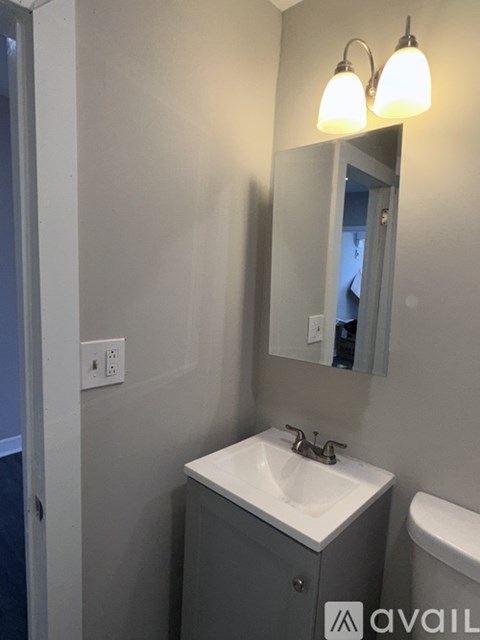 A bathroom with a sink, mirror, and toilet.