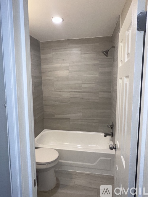A white toilet sits next to a bathtub in a bathroom.
