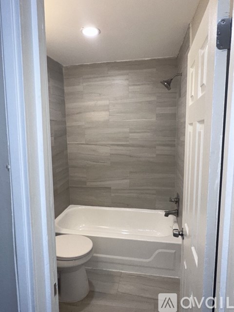 A white toilet sits next to a bathtub in a bathroom.