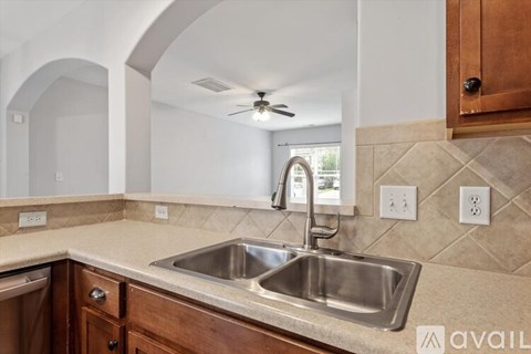 A kitchen with a sink and a fan.
