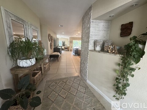 A living room with a white brick wall and a rug on the floor.