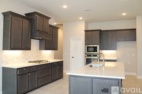 A kitchen with dark brown cabinets and a white countertop.