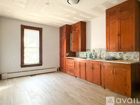 A kitchen with wooden cabinets and a window.