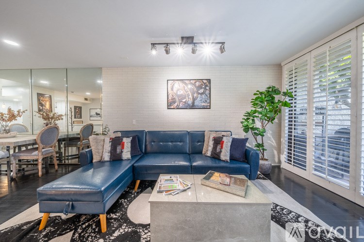 A blue sofa with a coffee table in front of it.