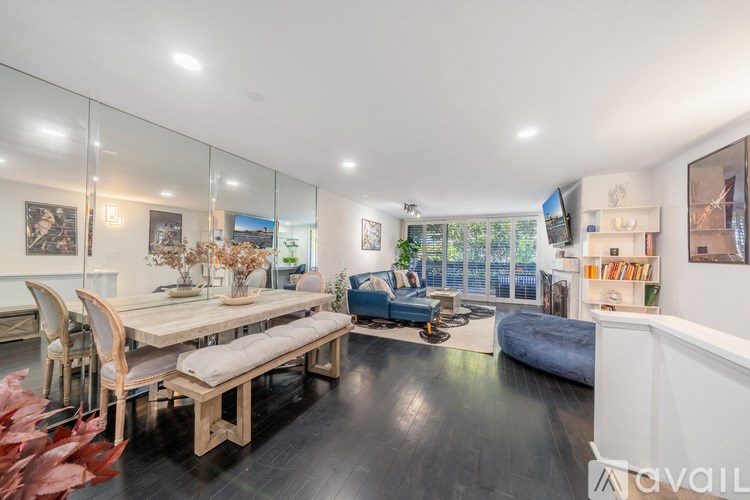 A modern living room with a glass wall and a wooden table.