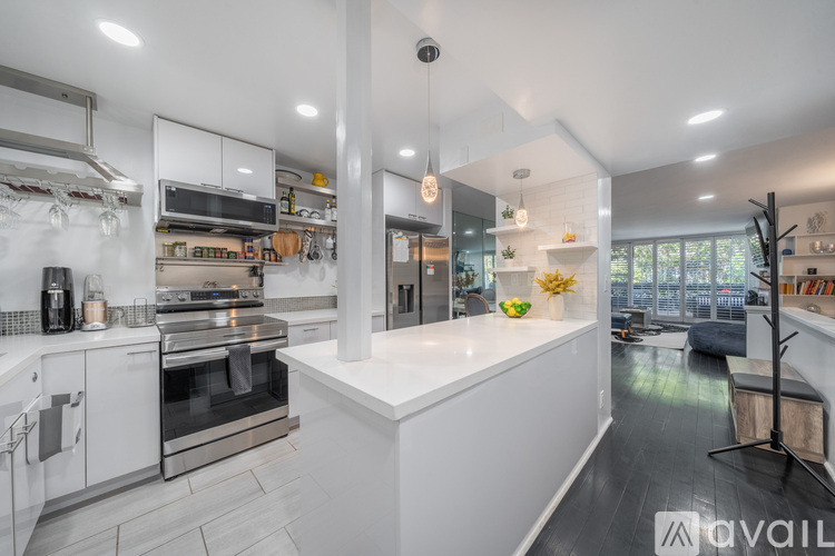 A modern kitchen with white cabinets and stainless steel appliances.
