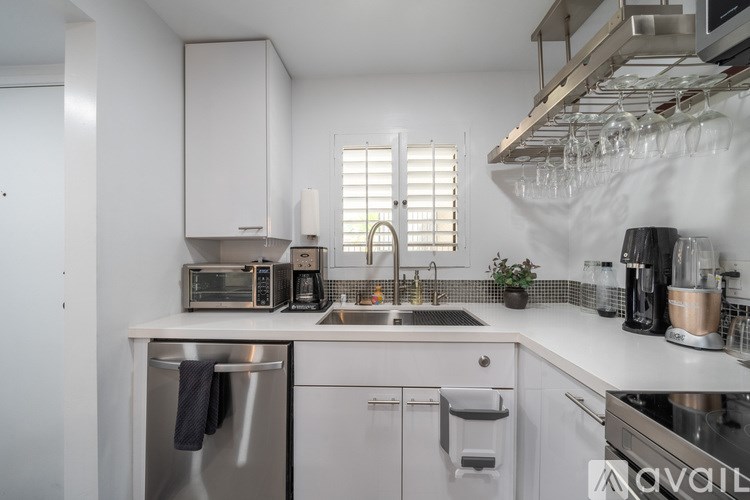 A modern kitchen with white cabinets and stainless steel appliances.