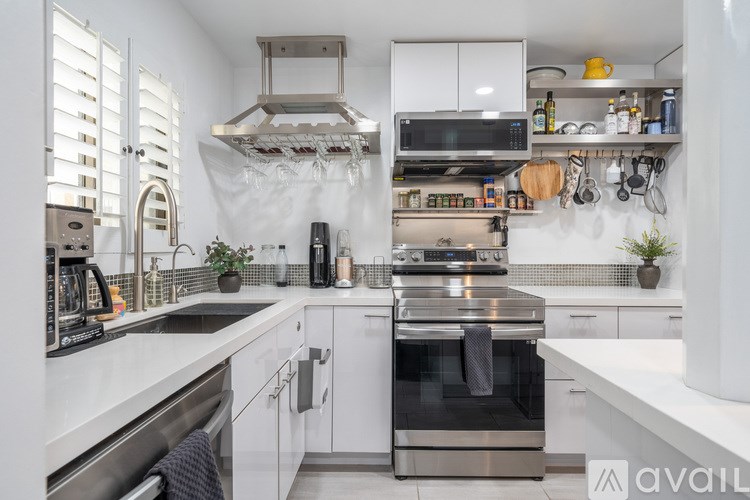 A modern kitchen with stainless steel appliances and white cabinetry.