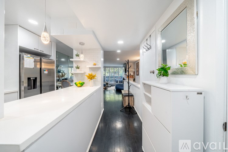 A modern kitchen with white cabinets and a black floor.