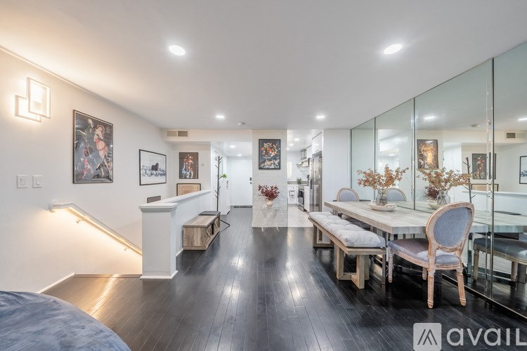 A modern living room with a glass dining table and chairs.