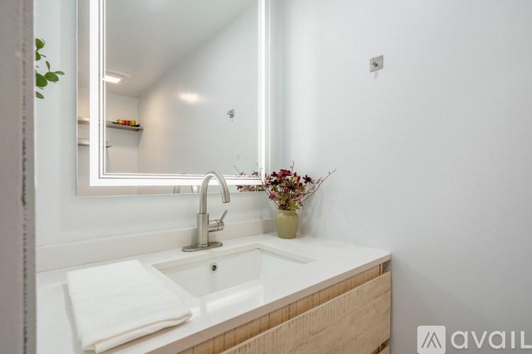 A bathroom sink with a white countertop and a silver faucet.