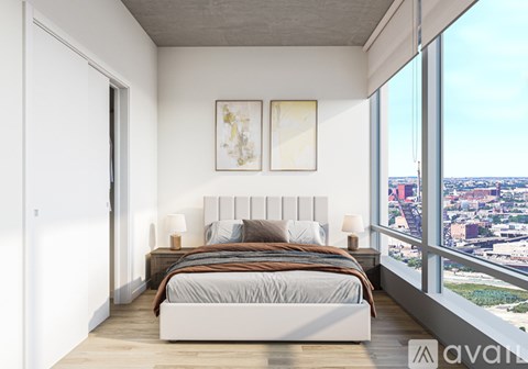 A bedroom with a large bed and a view of the city.