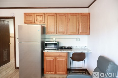 A kitchen with wooden cabinets and a refrigerator.
