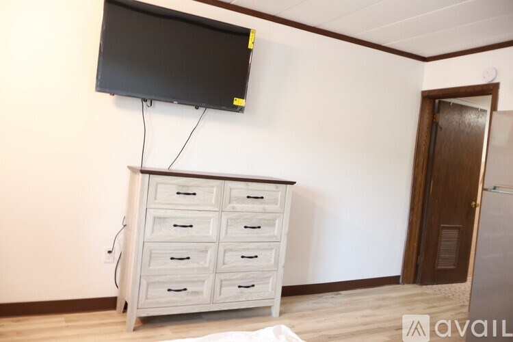 A white chest of drawers with a black TV above it.