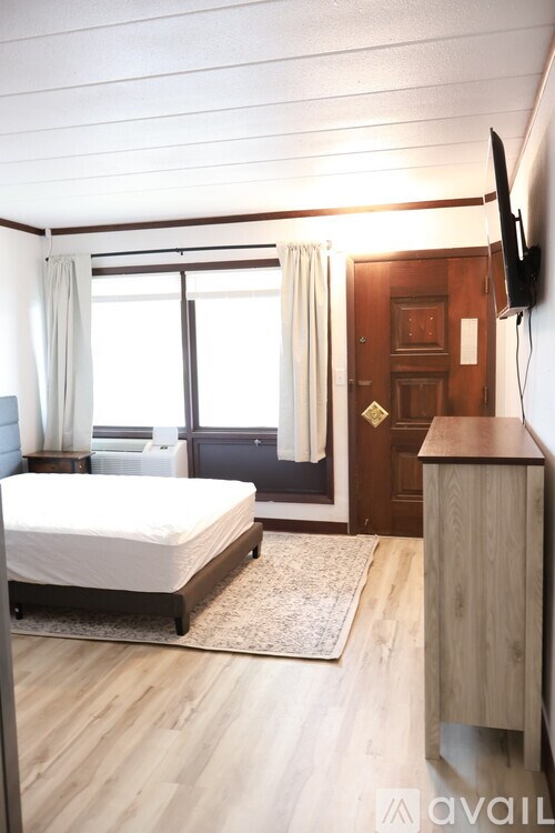 A bedroom with a bed, a dresser, and a window.