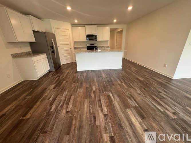 A kitchen with wooden floors and white walls.