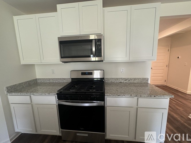 A kitchen with white cabinets and a granite countertop.