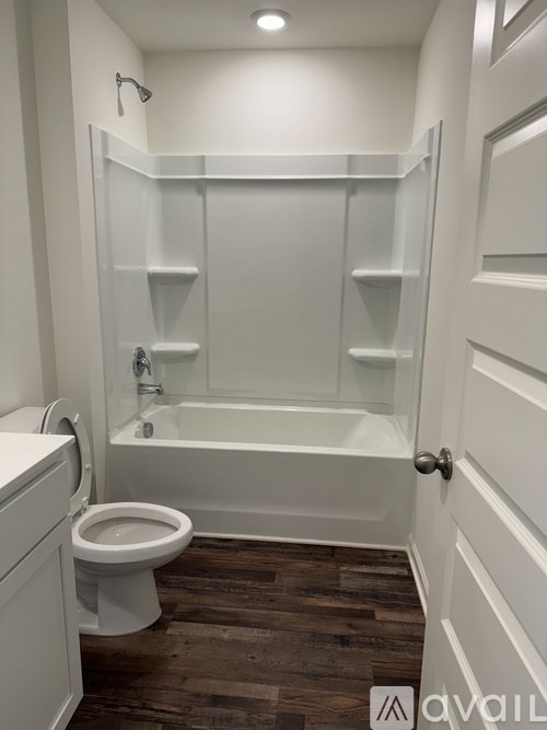 A white bathroom with a toilet, sink, and bathtub.