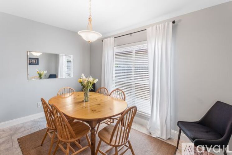 A dining room with a round wooden table and chairs.