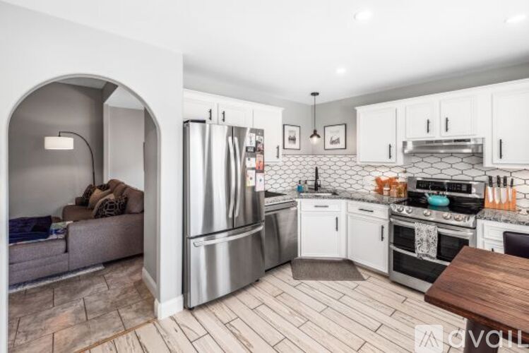 A kitchen with white cabinets and a wooden table.