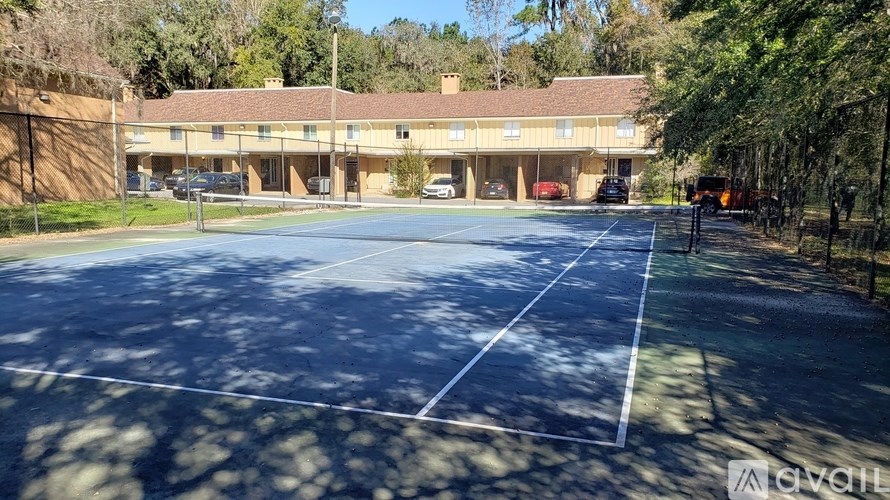 A large, empty parking lot in front of a building with a clear blue sky above.