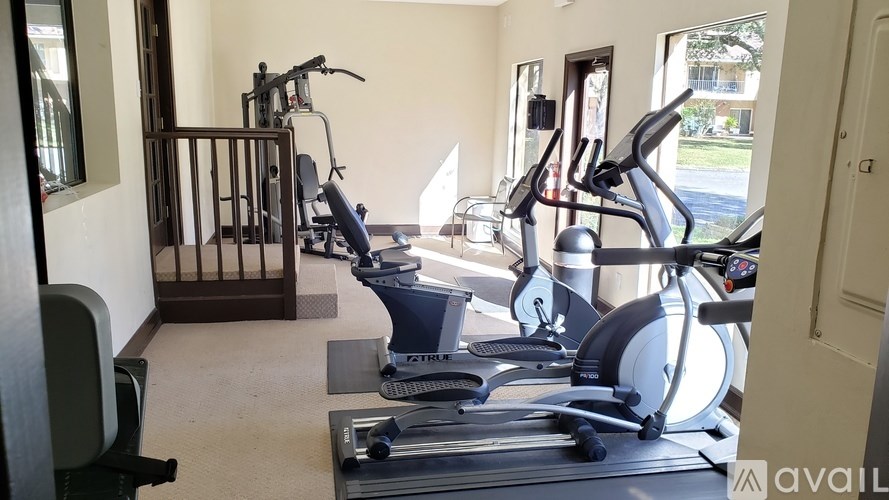 A gym with a variety of equipment including treadmills, stationary bikes, and weight machines.